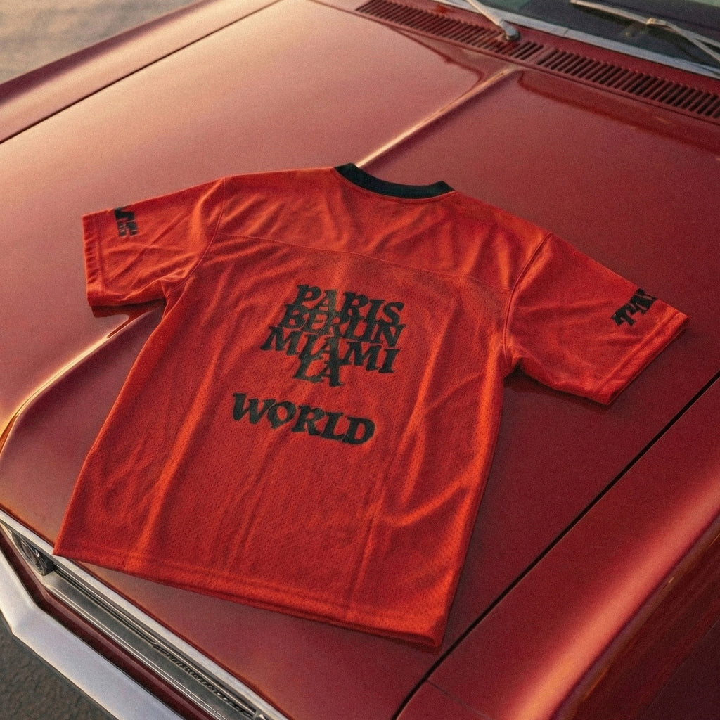 Red t-shirt with text on a red car hood
